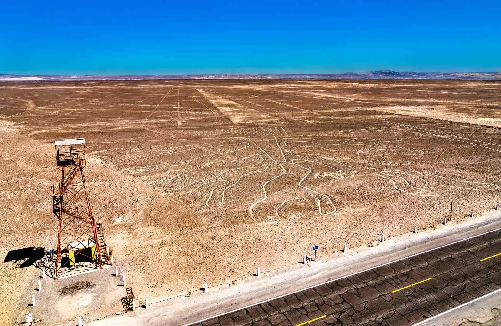 Vyhlídková věž u silnice Panamericana Sur s geoglyfem Ruce v pozadí, Nazca